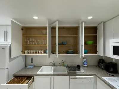 a kitchen with white cabinets and a sink at Ocean front 1 bedroom in Tropical Paradise in Hollywood