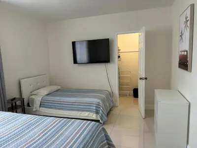 a bedroom with two beds and a television on the wall at Ocean front 1 bedroom in Tropical Paradise in Hollywood