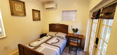 a bedroom with a bed and a table and a window at Cosy new studio with yard space in Miami in Miami