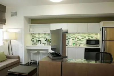 a living room with a couch and a kitchen at Element Miami Doral in Miami