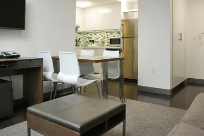 a kitchen with a wooden table and white chairs at Element Miami Doral in Miami