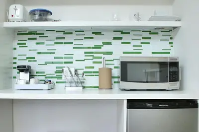 a kitchen counter with a microwave and a wall at Element Miami Doral in Miami