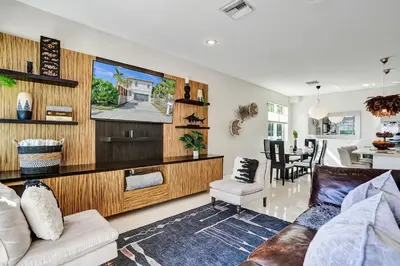 a living room with a couch and a tv at Tarpon River House - Heat Optional Pool - 4 bedrooms - 3 bathrooms - 1 miles to downtown FTL in Fort Lauderdale