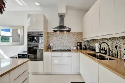 a white kitchen with white cabinets and a sink at Tarpon River House - Heat Optional Pool - 4 bedrooms - 3 bathrooms - 1 miles to downtown FTL in Fort Lauderdale