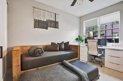 a bedroom with a bed and a desk with a computer at Tarpon River House - Heat Optional Pool - 4 bedrooms - 3 bathrooms - 1 miles to downtown FTL in Fort Lauderdale