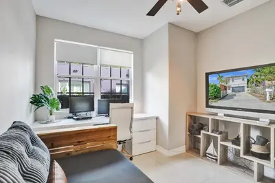 a room with a desk with a computer and a tv at Tarpon River House - Heat Optional Pool - 4 bedrooms - 3 bathrooms - 1 miles to downtown FTL in Fort Lauderdale
