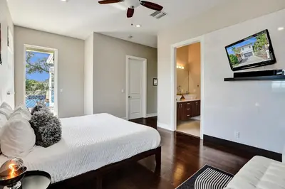 a bedroom with a bed and a tv on a wall at Tarpon River House - Heat Optional Pool - 4 bedrooms - 3 bathrooms - 1 miles to downtown FTL in Fort Lauderdale
