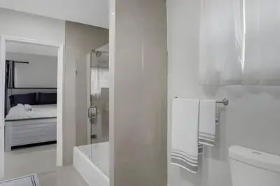 a white bathroom with a toilet and a bed at Luxury Miami Villa in North Miami