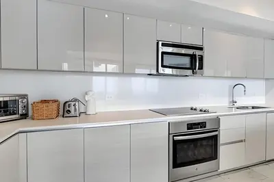 a white kitchen with white cabinets and a microwave at Million Dollar Penthouse with Pool Amazing Views in Hallandale Beach