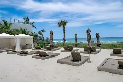 a group of chairs and umbrellas on the beach at Million Dollar Penthouse with Pool Amazing Views in Hallandale Beach