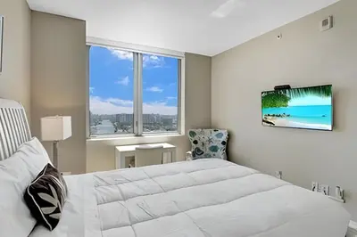 a white bedroom with a large bed and a window at Million Dollar Penthouse with Pool Amazing Views in Hallandale Beach