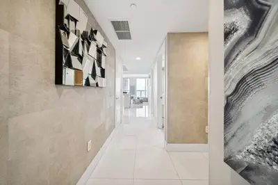 a hallway of a house with art on the walls at Million Dollar Waterfront Penthouse in Hallandale Beach