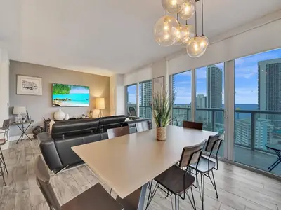 a living room with a table and a couch at Luxury Waterfront Suite with Great Views in Hallandale Beach
