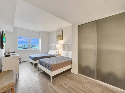 a hotel room with two beds and a shower at Luxury Waterfront Suite with Great Views in Hallandale Beach