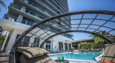 a resort with a pool and an arbor over a swimming pool at Top Floor Luxury Penthouse with Private Roof Deck in Hallandale Beach