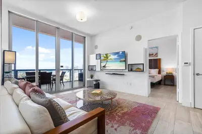a living room with a couch and a table at Top Floor Luxury Penthouse with Private Roof Deck in Hallandale Beach