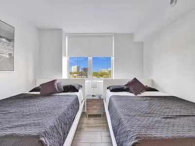 two beds in a room with a window at Luxury Waterfront Suite in Hallandale Beach