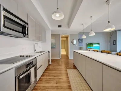 a kitchen with white cabinets and a counter top at Luxury Waterfront Condo in Hallandale Beach