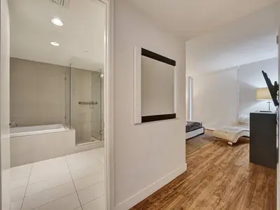a bathroom with a shower and a tub and a mirror at Luxury Waterfront Condo in Hallandale Beach