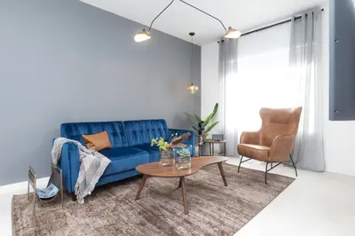 a living room with a blue couch and a table at Kasa Collins Park Miami Beach Convention Center in Miami Beach