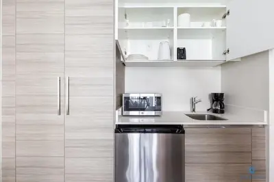 a kitchen with a stainless steel refrigerator and cabinets at Hollywood Bliss Studio Rooftop Pool in Hollywood