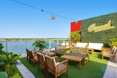 a patio with wooden tables and chairs and the water at Hollywood Bliss Studio Rooftop Pool in Hollywood