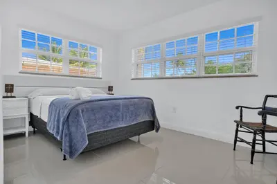 a white bedroom with a bed and two windows at Dolce Vita Hideaway Pool House by Pako Stays in Miami
