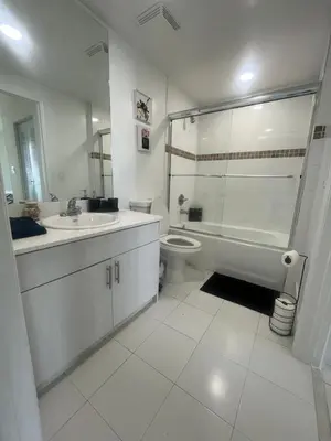 a bathroom with a toilet and a sink and a shower at Enjoy an endless summer - Parking included! in Sunny Isles Beach