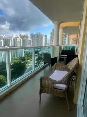 a balcony with chairs and a table and a view of the city at Enjoy an endless summer - Parking included! in Sunny Isles Beach