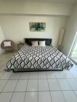 a bedroom with a bed with a black and white comforter at Enjoy an endless summer - Parking included! in Sunny Isles Beach