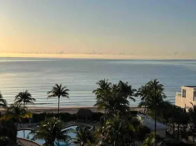 a view of the ocean from a resort with palm trees at 7th FL Ocean view spacious 1 bedroom in Hollywood