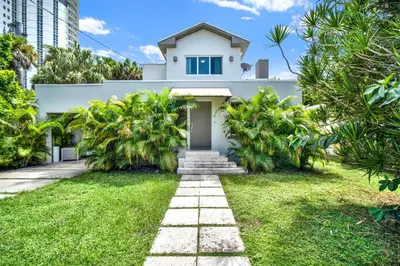 a white house with palm trees in front of it at Stunning Home LifeStyle Miami in Miami