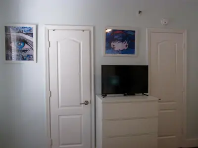 a room with a television and paintings on the wall at Lux Condo by the Beach in Miami Beach