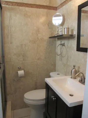 a bathroom with a toilet and a sink and a mirror at Lux Condo by the Beach in Miami Beach