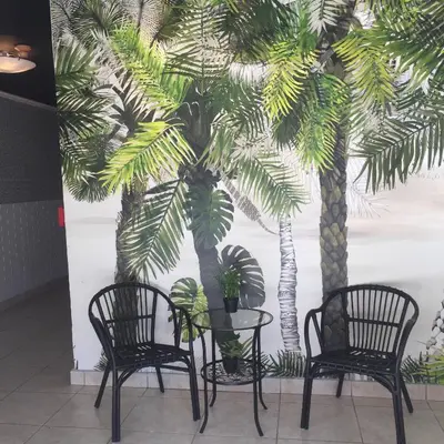 two chairs and a table in front of two palm trees at Lux Condo by the Beach in Miami Beach