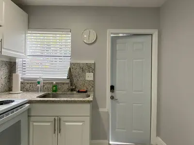 a kitchen with a sink and a clock on the wall at Annas Peaceful mini Luxury suite in Fort Lauderdale