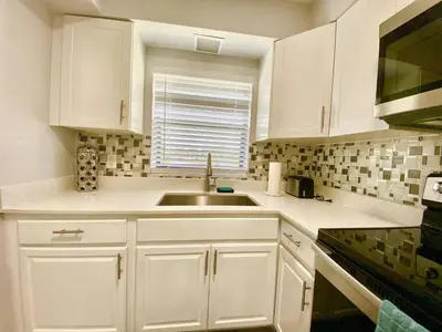 a kitchen with white cabinets and a sink at Anna's peaceful Getaway Luxury Suite in Fort Lauderdale