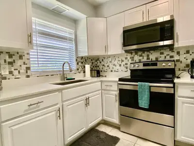a kitchen with white cabinets and a stove top oven at Anna's peaceful Getaway Luxury Suite in Fort Lauderdale