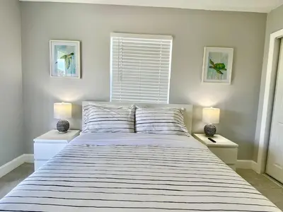 a bedroom with a large bed with two lamps at Anna's peaceful Getaway Luxury Suite in Fort Lauderdale