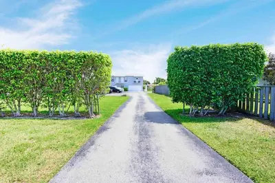 a tree lined driveway with trees and a fence at Anna's peaceful Getaway Luxury Suite in Fort Lauderdale