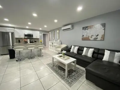 a living room with a black couch and a table at Executive Luxury Suite in Fort Lauderdale