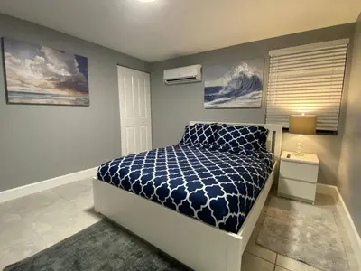 a bedroom with a bed with a blue and white comforter at Executive Luxury Suite in Fort Lauderdale