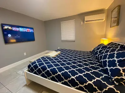 a bedroom with a bed and a flat screen tv at Executive Luxury Suite in Fort Lauderdale