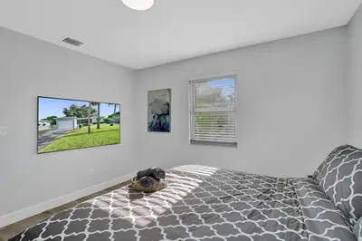 a bedroom with a bed and three pictures on the wall at The Front Wave Luxury Home in Fort Lauderdale