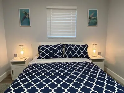 a bedroom with a blue and white bed with two night stands at Luxury home in Fort Lauderdale