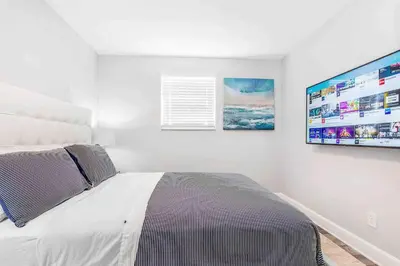 a bedroom with a bed and a flat screen tv at Mazor Luxury Two bedroom vacation Home in Fort Lauderdale