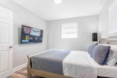 a bedroom with a bed and a tv on the wall at Mazor Luxury Two bedroom vacation Home in Fort Lauderdale