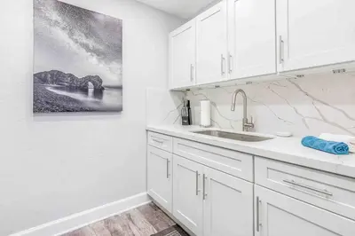 a white kitchen with white cabinets and a sink at Mazor Luxury Two bedroom vacation Home in Fort Lauderdale