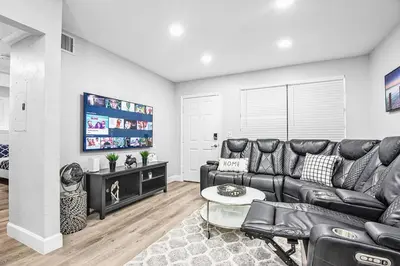a living room with a black leather couch and a tv at Rachaels Upscale Two Bedrooms Luxury Home in Fort Lauderdale