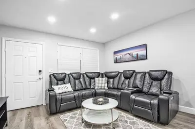 a living room with a leather couch and a table at Rachaels Upscale Two Bedrooms Luxury Home in Fort Lauderdale